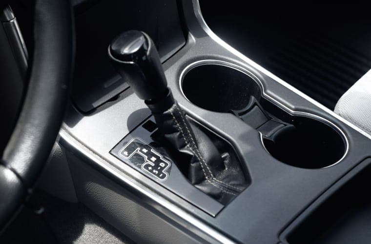 Car interior in daylight with the console cup holders in the foreground