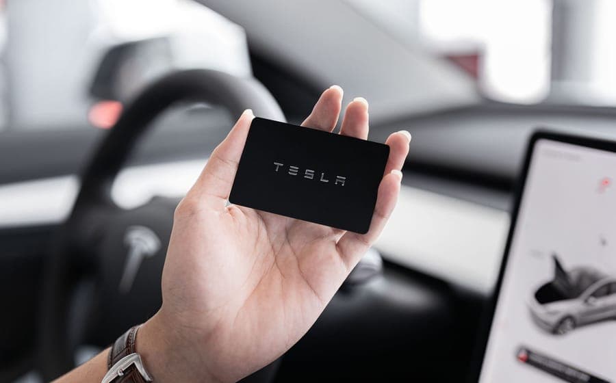 Hand holding a card key inside a car with the display lit behind