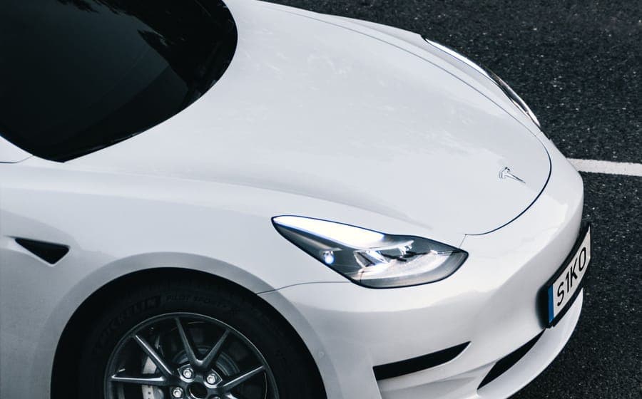 Overhead view of a white Tesla driving along a city street