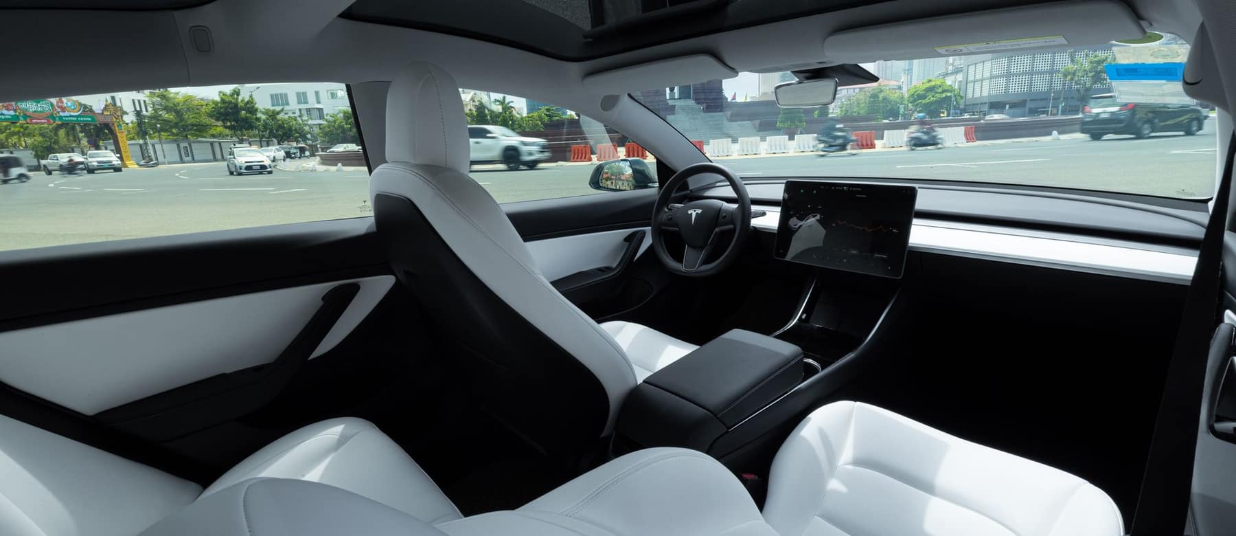 Tesla cabin interior with the center touchscreen and console visible from the rear seats