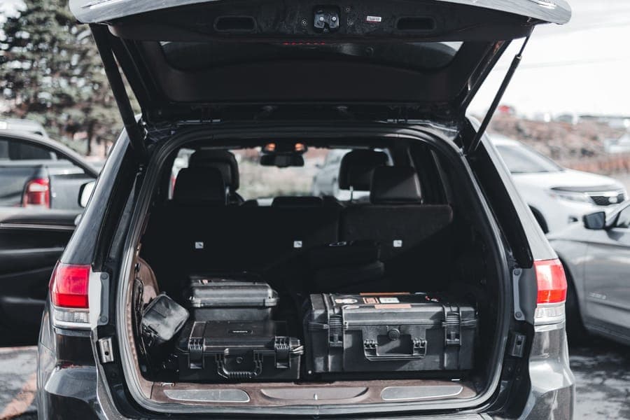 Open SUV cargo area loaded with hard equipment cases