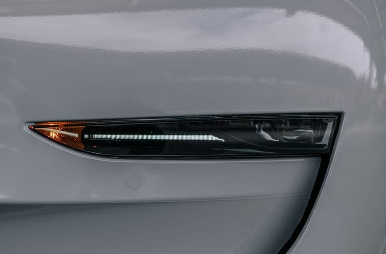 Close-up of the lower front bodywork and wheel arch of a white electric car