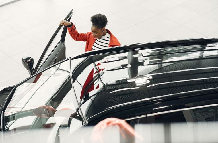 Person opening a car door with the door sill visible at the threshold