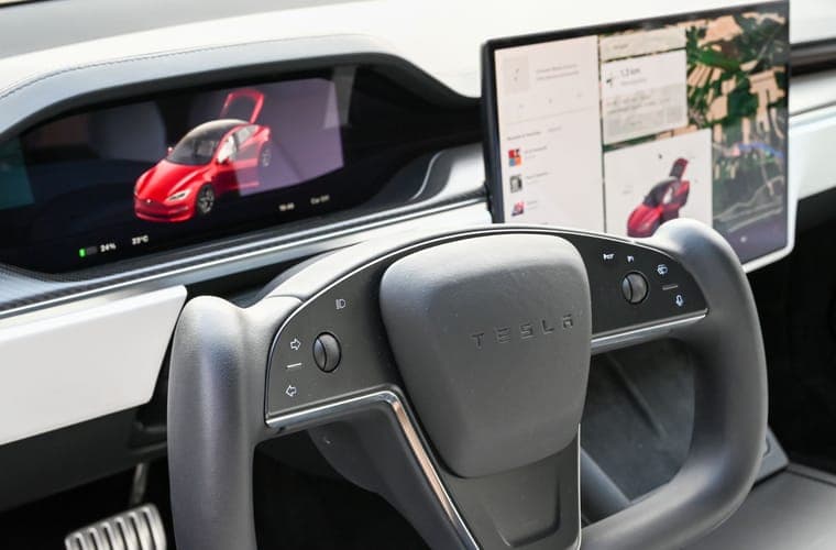 Tesla dashboard with the center display and steering wheel in frame